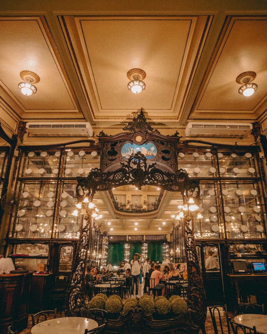A carved wooden arch and mirrored cabinets inside Confeitaria Colombo in Rio de Janeiro