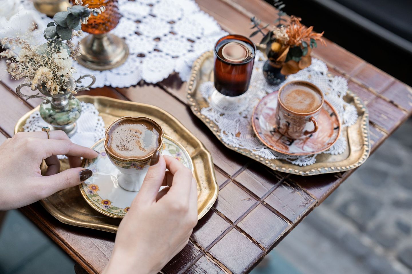 Two cups of Turkish coffee on ornate gold saucers and a lace cloth