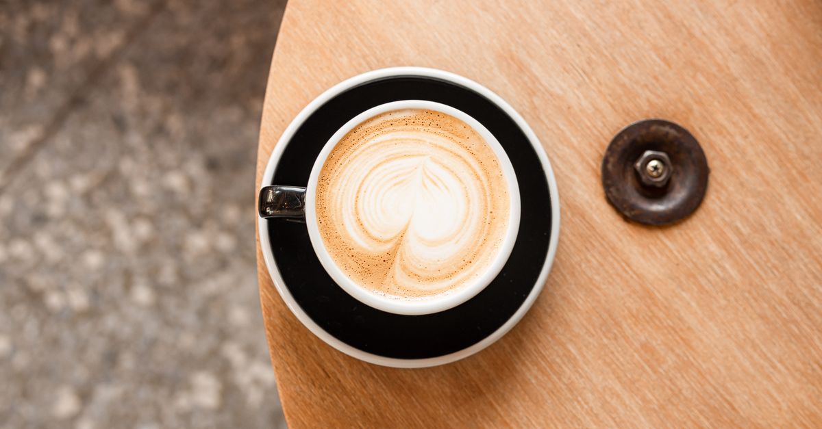 Espresso cups on a warm wooden café counter, illustrating networking as an ordinary coffee chat