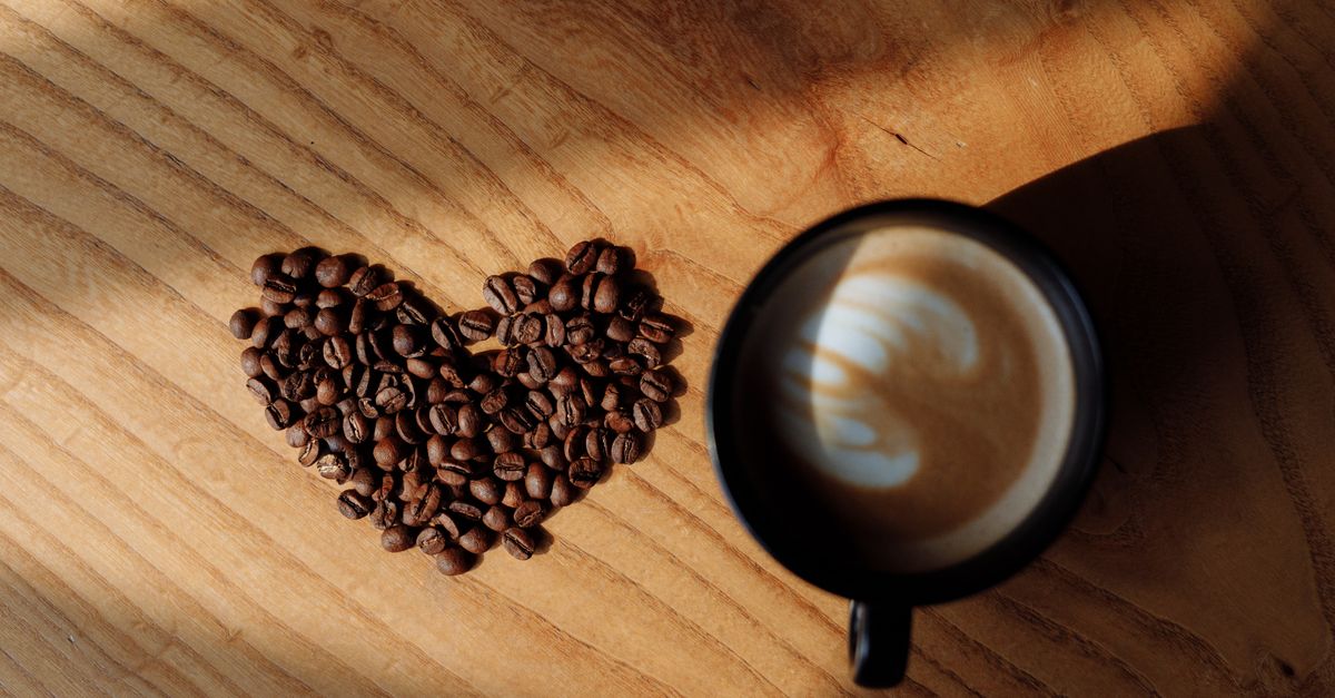 A flat white on a wooden table in morning light, illustrating slow dating and meeting one person at a time