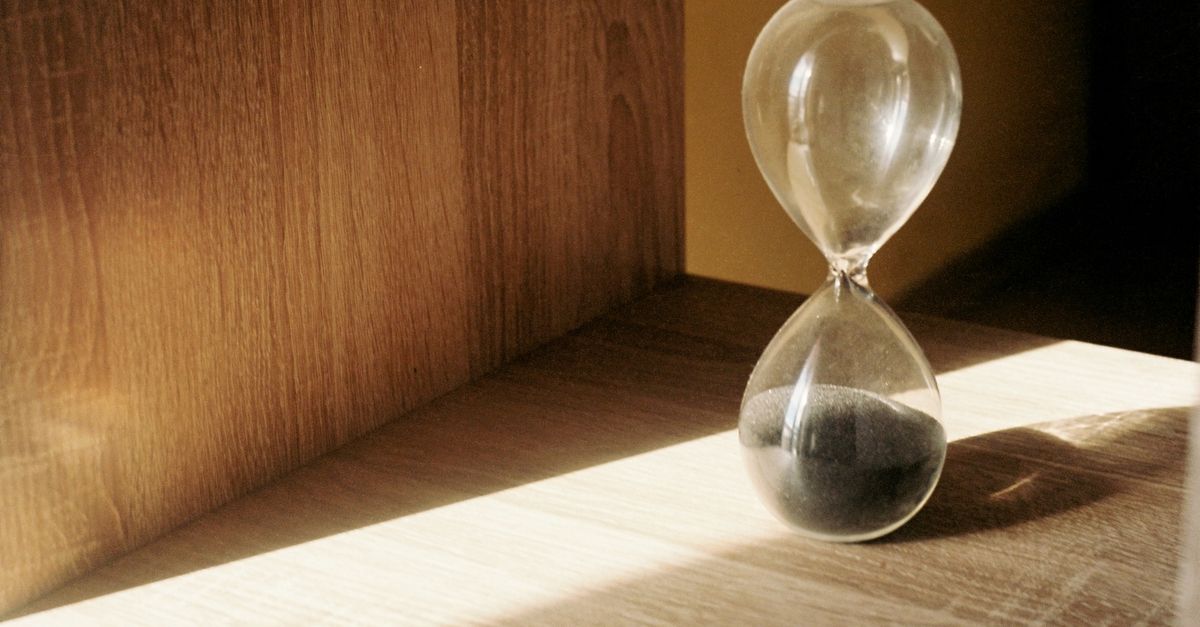 A vintage clock face on a warm wooden shelf, marking the fifty hours it takes to make a friend
