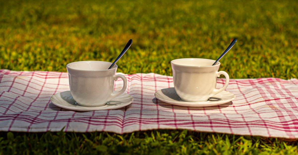 Two mugs side by side on a wooden bench, illustrating the friendship recession among men