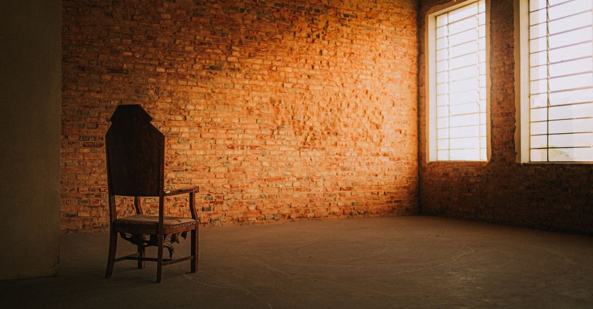 An empty armchair beside a window in morning light, on why a feed is not the same as company
